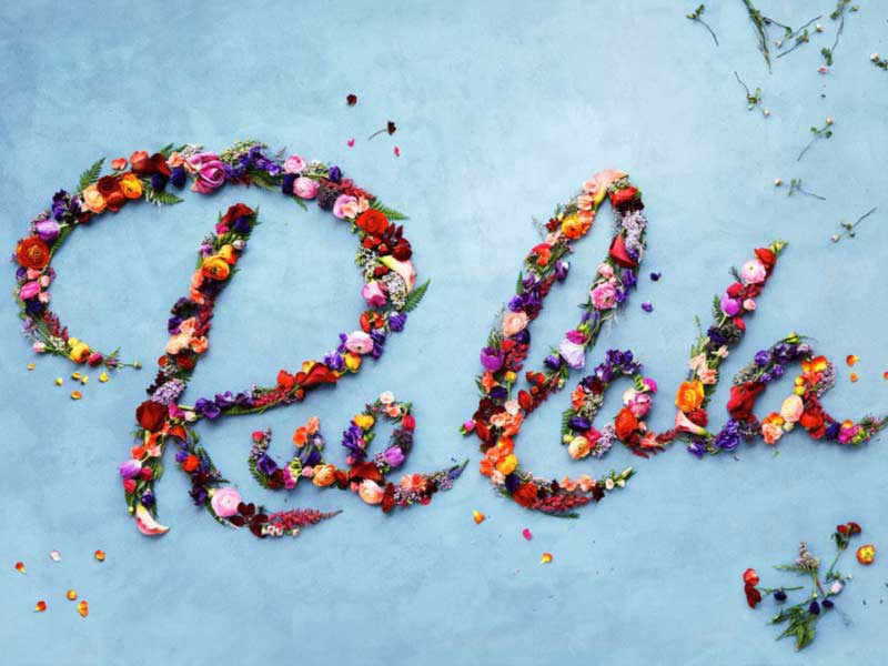 “RueLaLa” spelled out in flower petals on a sky-blue backdrop